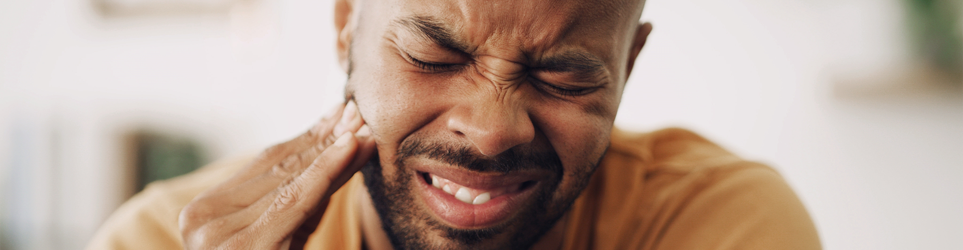 Man holding his cheek in pain.
